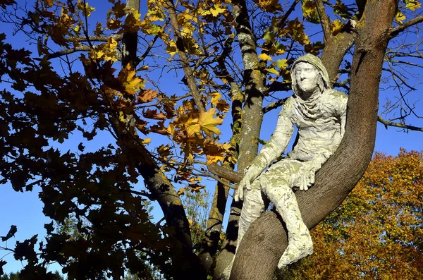 木の上に座って石膏の男 — ストック写真