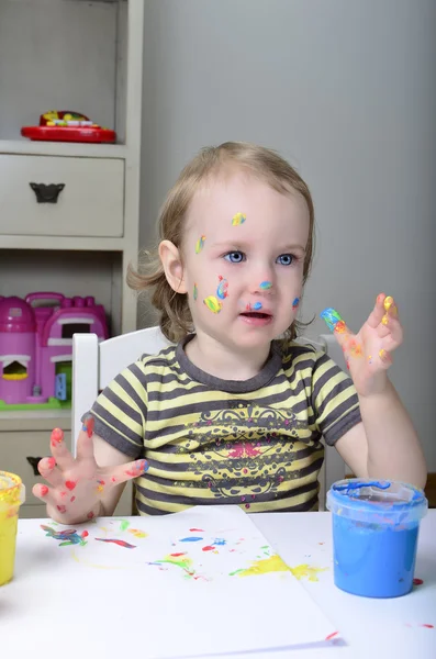 Маленькая девочка и цветные краски — стоковое фото