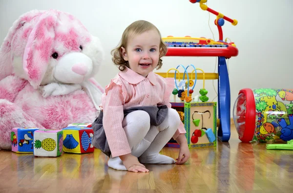 Liten flicka i ett rum med leksaker — Stockfoto
