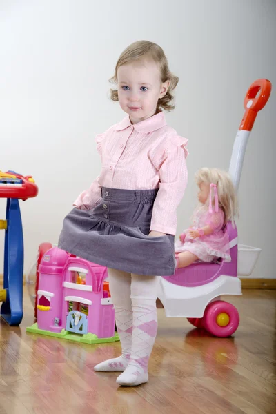 Küçük kız oyuncakları ile bir odada ayakta — Stok fotoğraf
