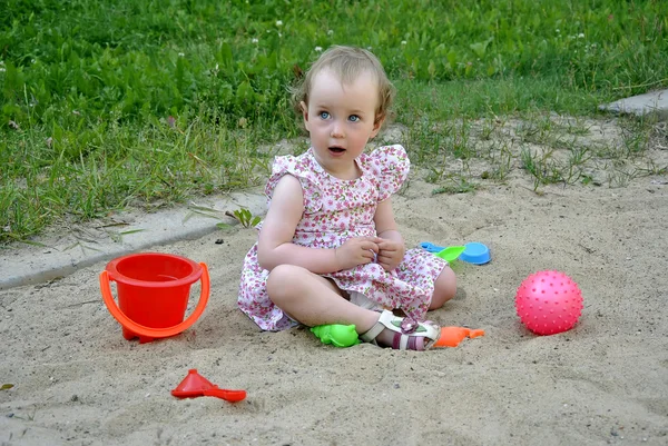 Malá holčička hraje na pískovišti — Stock fotografie