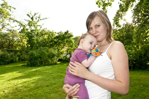 Młoda matka w ogrodzie z dzieckiem — Zdjęcie stockowe