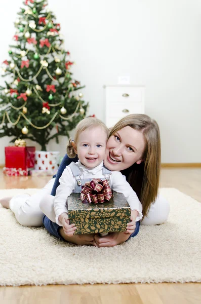 Little girl and her mother holding gift at Christmas — Stock Photo, Image