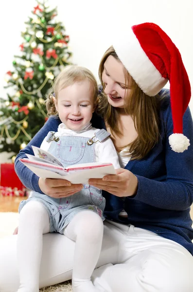 女孩和她妈妈读本书在圣诞节 — 图库照片