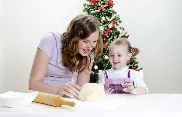 Mała dziewczynka i matki przygotowują świąteczne ciasteczka — Zdjęcie stockowe