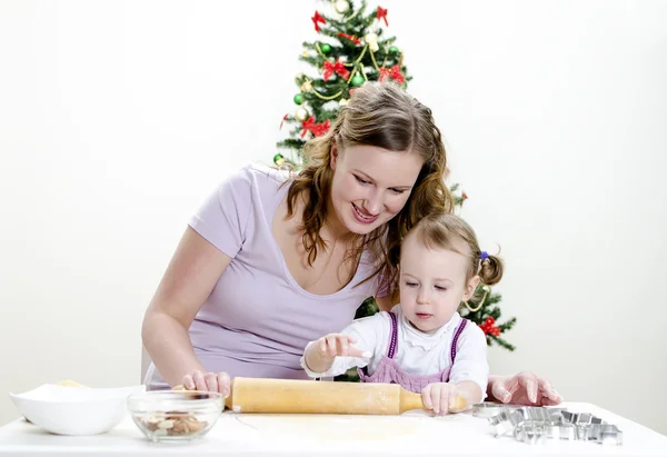 小さな女の子と、母はクリスマスのクッキーを準備しています。 — ストック写真