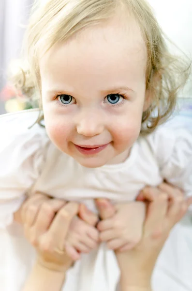 Hravá holčička v rukou matka — Stock fotografie