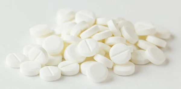 Pilules blanches sur fond blanc — Photo