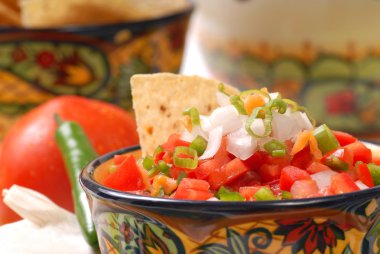 Spicy salsa with tortilla chips clipart