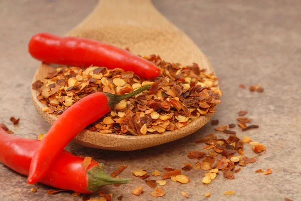 stock image Red chili peppers and red pepper flakes on a spoon