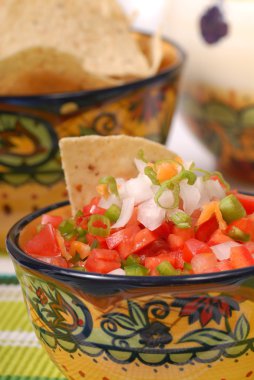 Spicy salsa with tortilla chips clipart