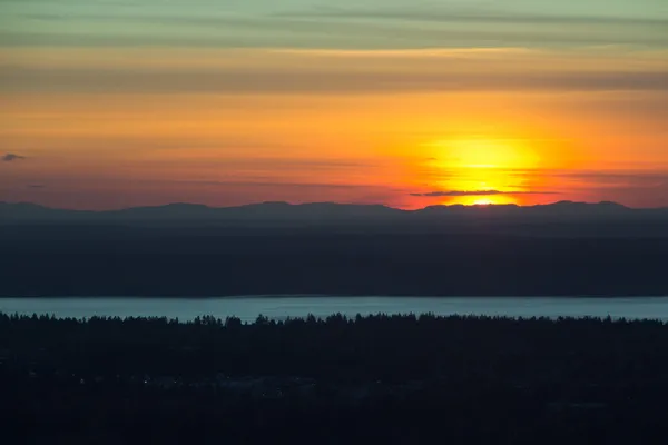 Linhas horizontais de céu, montanhas e água ao pôr do sol — Fotografia de Stock