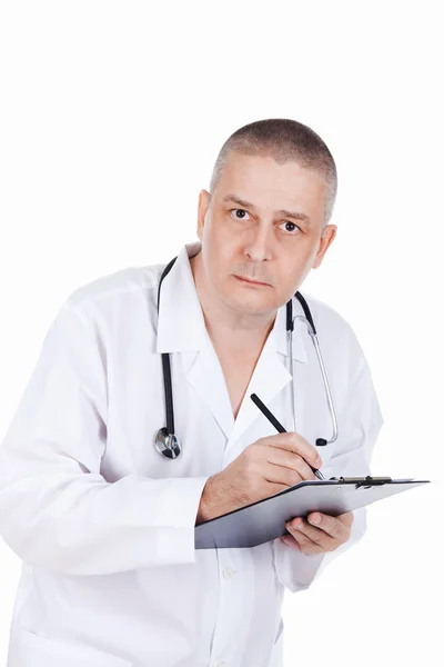 Adult doctor with clipboard takes notes and writes recipes — Stock Photo, Image