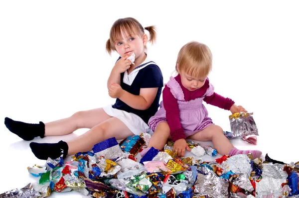 Little girls in candy wrappers from sweets — Stock Photo, Image