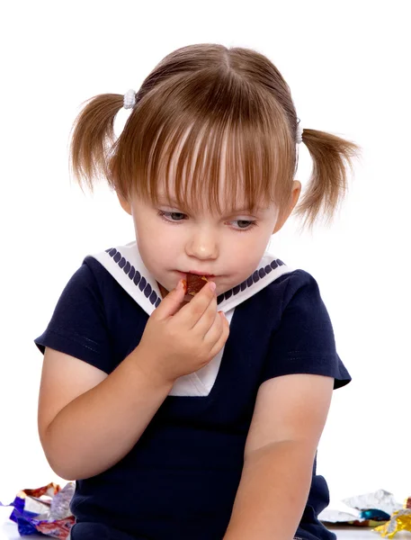 The little girl eats a chocolate Rechtenvrije Stockfoto's