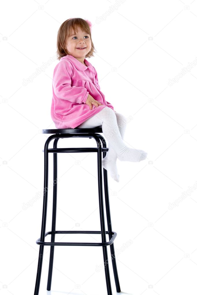 The little girl sits on a high chair