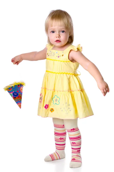 Das kleine Mädchen kostet mit einem Partyhut in der Hand — Stockfoto