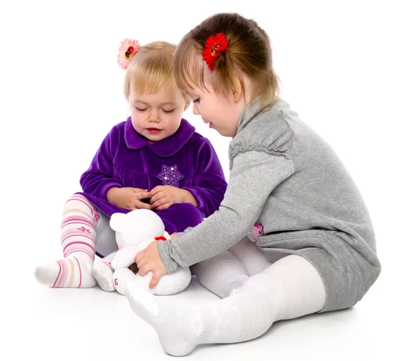 Две девушки играют с плюшевым мишкой — стоковое фото