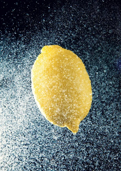 Spritzer Wasser um eine gelbe Zitrone — Stockfoto