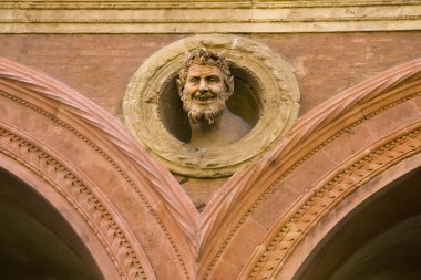 The devil's head decoration on medieval building in Bologna clipart