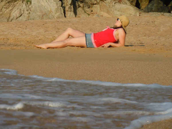 해변에서 쉬고 있는 젊은 여자 — 스톡 사진