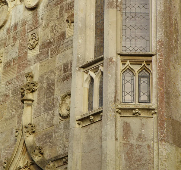 Fenêtres et sculptures sur un mur de château — Photo