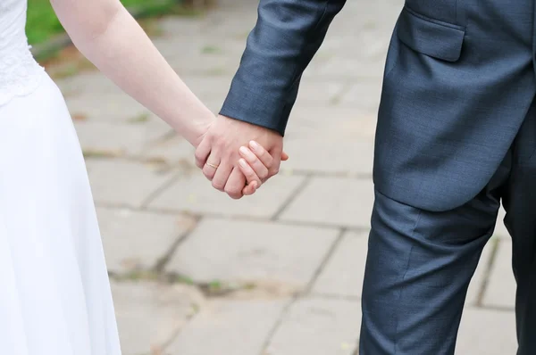 Bruid en bruidegom hand in hand — Stockfoto