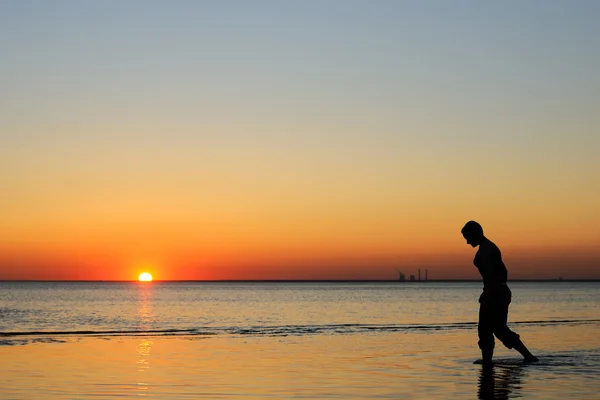 Bald woman as silhouette by the sea — Stok fotoğraf