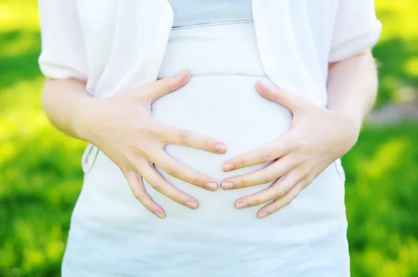 Руки на беременном животе — стоковое фото