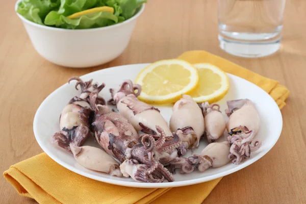 Tintenfisch auf Teller mit Zitrone — Stockfoto