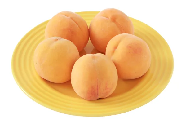 Peaches on yellow plate — Stock Photo, Image