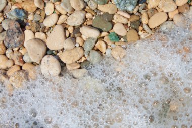 çakıl taşları ve köpük sahilde, yakın