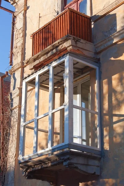 Старый дом с новым пластиковым окном на балконе — стоковое фото