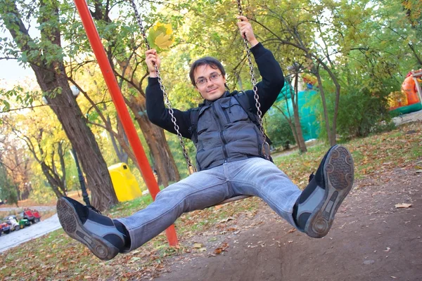 Young smiling man on swing — Stock Photo, Image