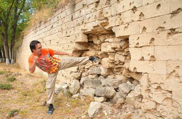 젊은 남자 깨는 벽돌 벽 — 스톡 사진