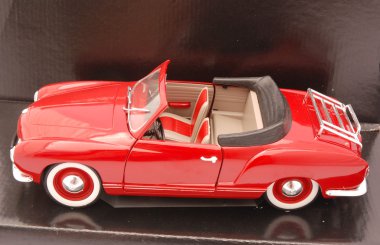 A dirty red cabrio car toy for kids in a glossy black gift box clipart