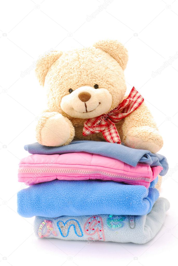 Teddy on stack of kids clothes