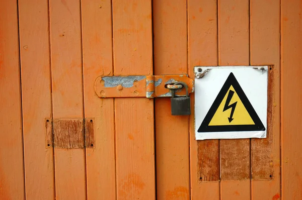 Деревянная дверь с предупреждающим знаком — стоковое фото