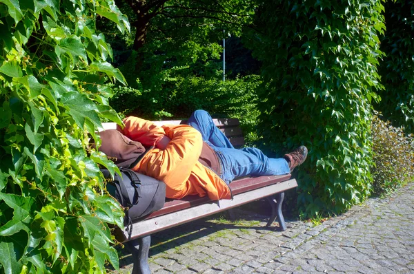 Bezdomny śpi na ławce — Zdjęcie stockowe