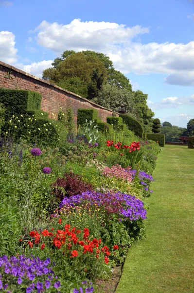 Engelse tuin met oude muur — Stockfoto