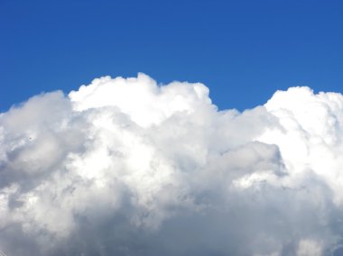 Mavi gökyüzü gün ışığı kabarık beyaz bulutlar ile