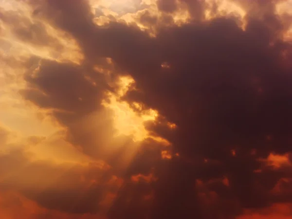 Драматические солнечные лучи среди облаков в небе — стоковое фото
