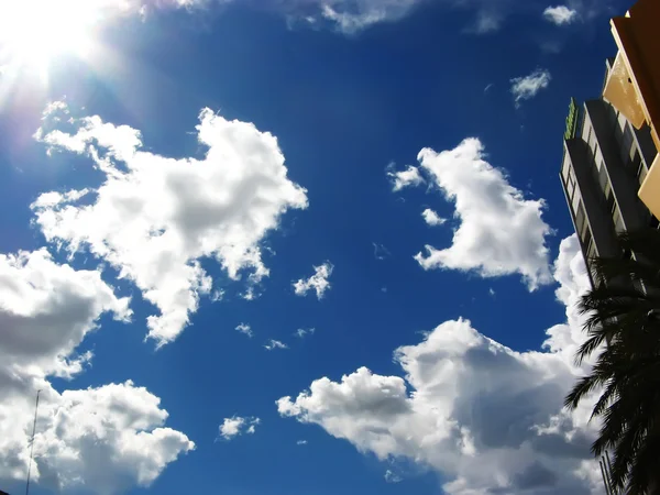 日の光でふわふわの白い雲と青い空 — ストック写真