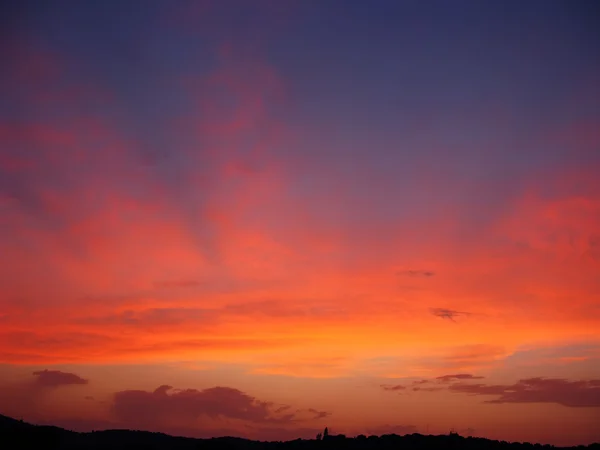 Pôr do sol roxo vibrante e colorido com silhueta de montanha — Fotografia de Stock
