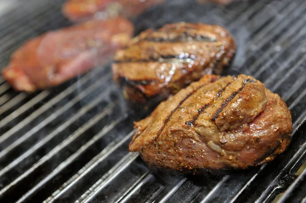 Bife de carne cozinhando em uma grelha de chama aberta — Fotografia de Stock