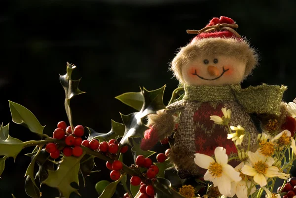 Kerstmis, sneeuwpop op een tak van Hulst — Stockfoto