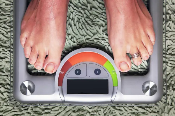 Woman on the weight scale — Stock Photo, Image