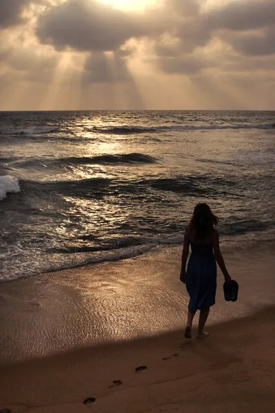 Κορίτσι σε μια παραλία στο ηλιοβασίλεμα — Φωτογραφία Αρχείου