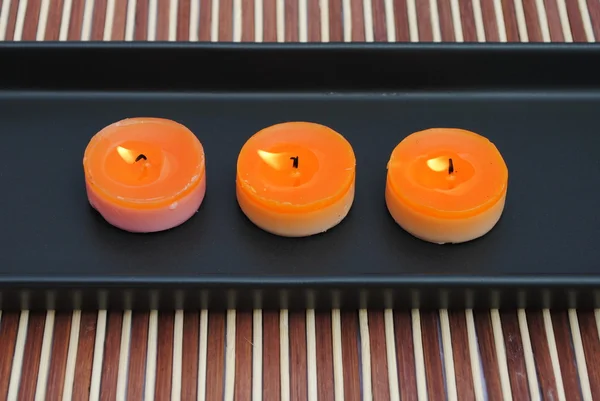 Oranžové svíčky v černém misce na bambus — Stock fotografie