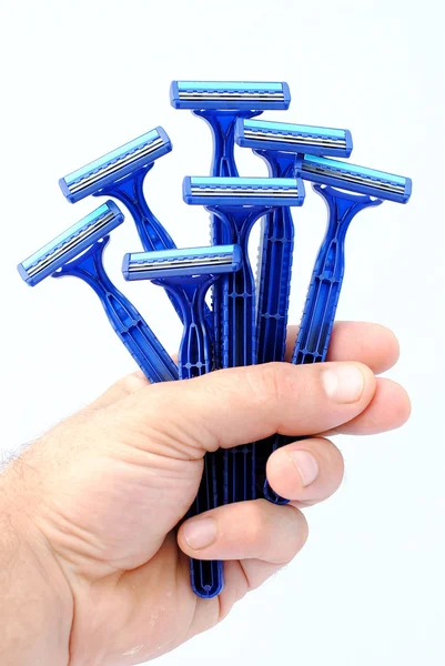 Чоловік тримає сім одноразових синіх бритв — стокове фото